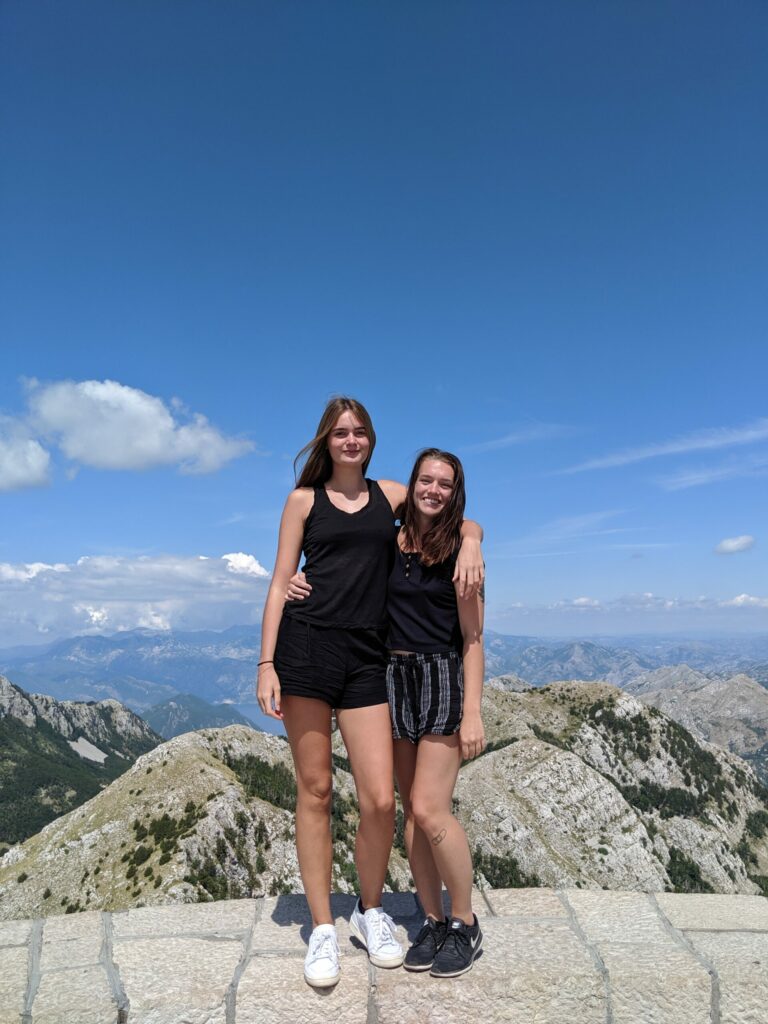 Justyn and Alex standing at the viewpoint overlooking the mountains of Montenegro.