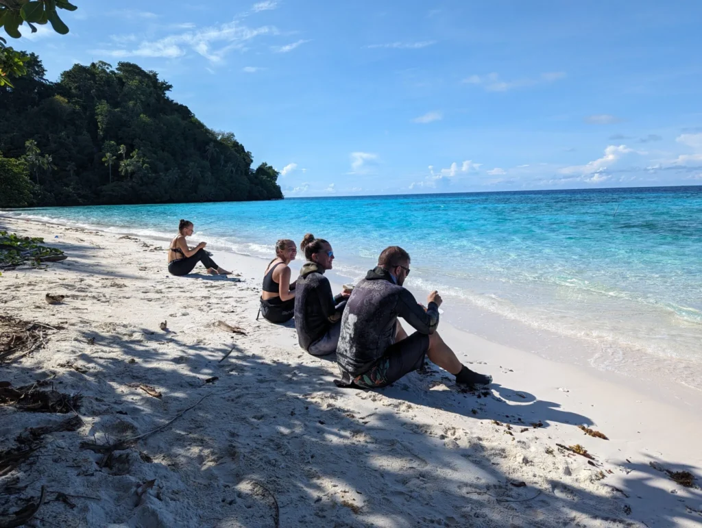 4 divers having breakfast on the beach at Si Amil Island.