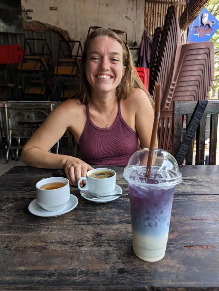 Justyn drinking a coffee with butterfly tea in Siem Reap.