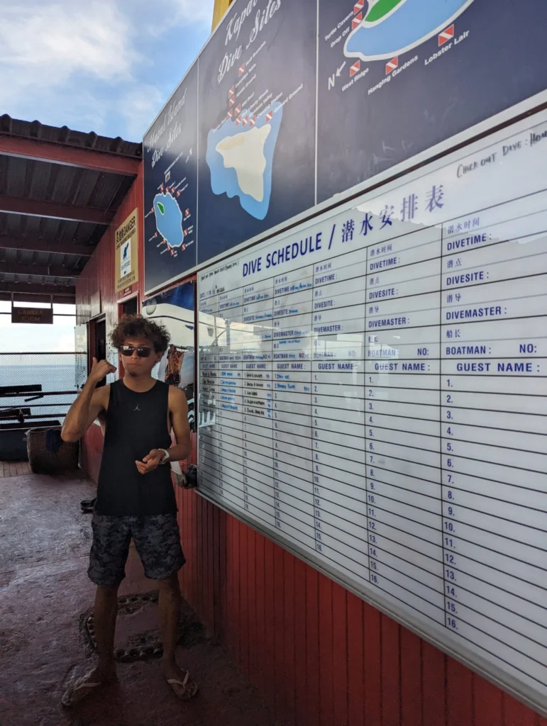 Our guide Wan showing us the dive schedule on the rig.