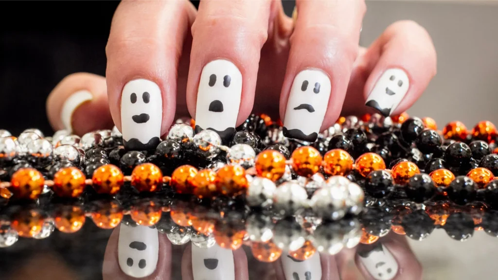 Ghost nails sitting on a orange, silver and black beads.