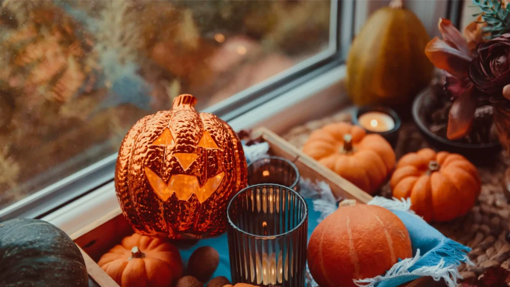 A flatlay with fall items like candles, sparkly pumpkins and plush pumpkins.